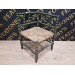 A LATE 19TH EARLY 20TH CENTURY GREEN PAINTED BOBBIN TURNED CORNER CHAIR WITH RUSH SEAT