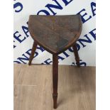 A 20TH CENTURY CONTINENTAL CARVED OAK TRIPOD STOOL WITH SHIELD SEAT