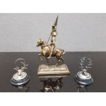 A BRASS SCULPTURE OF JOAN OF ARC TOGETHER WITH TWO LOADED SILVER PLACE HOLDERS IN THE FORM OF STAG