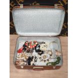 A VINTAGE SUITCASE CONTAINING ASSORTED COSTUME JEWELLERY