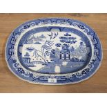 A 19TH CENTURY BLUE AND WHITE TRANSFER WILLOW PATTERN MEAT DISH 48.5CM LONG