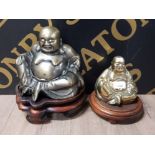 A BRASS BUDDHA PLUS A BRASS EFFECT BUDDHA BOTH ON WOODEN PLINTHS ONE PLINTH NEEDS ATTENTION