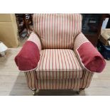 A BARKER AND STONEHOUSE ARMCHAIR UPHOLSTERED IN STRIPED MATERIAL RAISED ON BRASS CASTORS