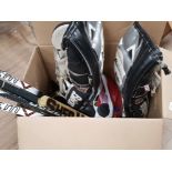 BOX OF HOCKEY SPORTING EQUIPMENT INCLUDES SHIN GUARDS, HOCKEY STICKS AND BAG OF PUCKS ETC