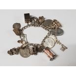 HALLMARKED SILVER CHARM BRACELET WITH 23 CHARMS INCLUDING SILVER 3 PENCES AND EMERGENCY 1 POUND