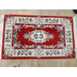 A MODERN CHINESE RUG FLORAL DECORATION ON RED GROUND 160 X 92CM