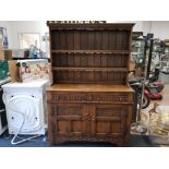A CARVED OAK KITCHEN DRESSER IN THE OLD CHARM STYLE 122 X 173 X 46.5CM
