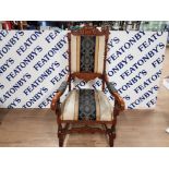 AN ORNATELY CARVED OAK HALL CHAIR THE BACK ARMS UPHOLSTERED IN STRIPED FLORAL FABRIC 122CM HIGH