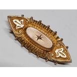 A VICTORIAN YELLOW METAL ETRUSCAN PATTERN BROOCH WITH CENTRAL WHITE STONE, 3.8G