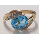9CT YELLOW GOLD BLUE STONE SOLITAIRE TWIST RING WITH DIAMOND SHOULDERS, 2.9G SIZE M1/2