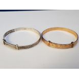A CHILDS GOLD ON METAL BANGLE 48MM X 5MM, 6.7G TOGETHER WITH A CHILDS SILVER BANGLE OF SAME SIZE 5.