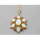 A 9CT YELLOW GOLD OPAL AND RUBY PENDANT ON 9CT GOLD CHAIN 6.6G GROSS