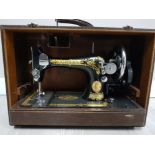 AN ANTIQUE SINGER SEWING MACHINE IN CROCODILE SKIN EFFECT CASE