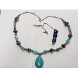 A TURQUOISE AND WHITE GOLD PLATED METAL NECKLACE TOGETHER WITH A CARVED BLUE STONE PENDANT