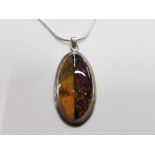 AN AMBER TYPE AND SILVER PENDANT ON SILVER CHAIN 18.9G GROSS