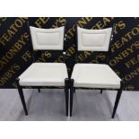 A PAIR OF CREAM LEATHERETTE AND BLACK PAINTED WOODEN DINING CHAIRS
