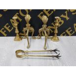 A PAIR OF BRASS ANDIRONS WITH CLAW AND BALL DECORATION TOGETHER WITH A PAIR OF BRASS CANDLESTICKS