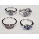 FOUR SILVER AND PURPLE STONE RINGS STAMPED SIZES N 1/2 R 1/2 S AND U