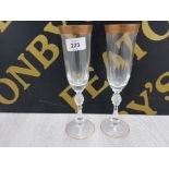 A PAIR OF CUT CRYSTAL CHAMPAGNE FLUTES WITH GILT RIMS