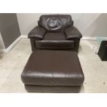 A MODERN BROWN LEATHER EASY CHAIR WITH POUFFE