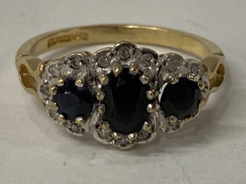 9CT YELLOW GOLD BLACK SAPPHIRE AND DIAMOND CLUSTER RING COMPRISING OF AN OVAL SAPPHIRE STONE SET