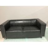 A MODERN LEATHER TWO SEATER SETTEE IN BLACK
