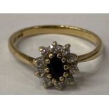 9CT YELLOW GOLD OVAL BLACK STONE SET IN A CLAW SETTING SURROUNDED BY A CLUSTER OF CUBIC ZIRCONIAS