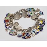 A SILVER BRACELET WITH APPROXIMATELY 40 SILVER SOUVENIR SHIELDS 57.4G GROSS