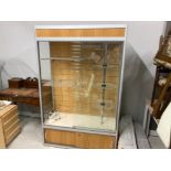 A MODERN LAMINATE AND GLASS DISPLAY CABINET WITH CIRCULAR THREE TIER ROTATING STAND AND TWO
