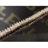 A 9CT YELLOW GOLD AND DIAMOND FANCY PATTERN TENNIS BRACELET OVER 1CT IN DIAMONDS 16.5CM LONG