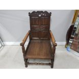 A CARVED OAK LOUNGER PROBABLY BY COUNTRY FORM WITH LINEN FOLD DECORATION