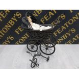 A VINTAGE CHILDS TOY PRAM CONTAINS PORCELAIN HEADED DOLL TOGETHER WITH A CAST METAL TRIKE