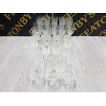 A LARGE QUANTITY OF DRINKING GLASSES SUCH AS CHAMPAGNE FLUTES WHISKEY TUMBLERS ETC