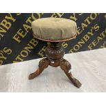 A HEAVILY CARVED MAHOGANY TRI-LEGGED PIANO STOOL WITH STUDDED AND ADJUSTABLE SEAT
