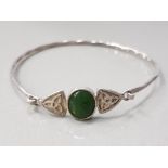 A SILVER CELTIC BANGLE WITH JADE CENTRE STONE 5.3G GROSS
