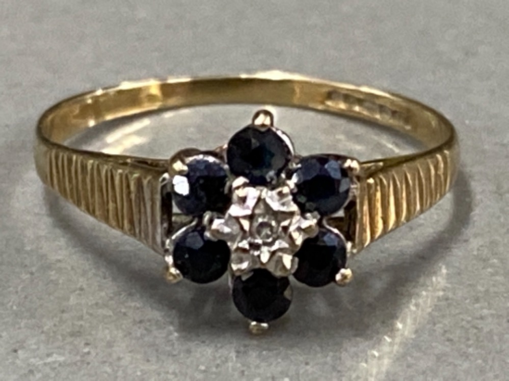 9CT YELLOW GOLD CLUSTER RING WITH DIAMOND CENTRE STONE SURROUNDED BY 6 BLUE STONES, 1.2G SIZE J