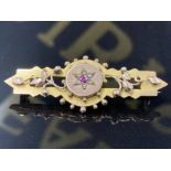 AN ANTIQUE 9CT YELLOW GOLD BROOCH WITH CENTRAL PINK STONE SURROUNDED BY SIX SEED PEARLS 3.8G GROSS