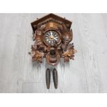 A VINTAGE WEST GERMAN BLACK FOREST STYLE CUCKOO CLOCK WITH PENDULUM AND ACORN WEIGHTS
