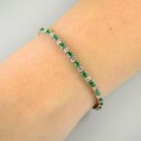 A platinum emerald and brilliant-cut diamond line bracelet.