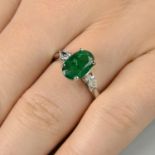 An emerald and pear-shape diamond three-stone ring.