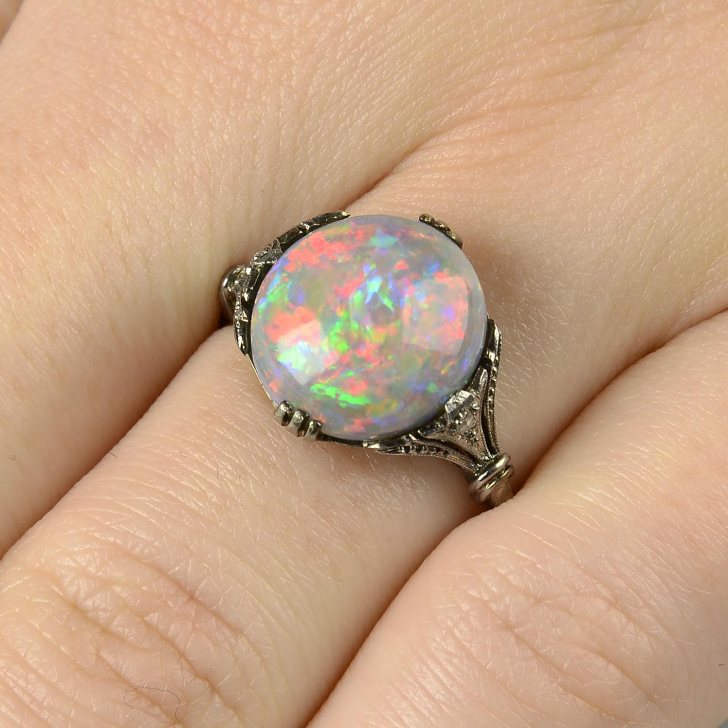 A black opal and rose-cut diamond accent ring.Opal weight 4.61cts.Ring size M.