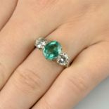 An emerald and brilliant-cut diamond three-stone ring.