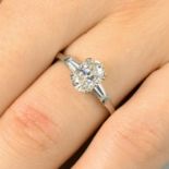A platinum oval-shape diamond single-stone ring, with tapered baguette-cut diamond shoulders.