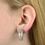A pair of diamond accent earrings, with stylised floral motif.