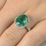 An emerald and diamond cluster ring.