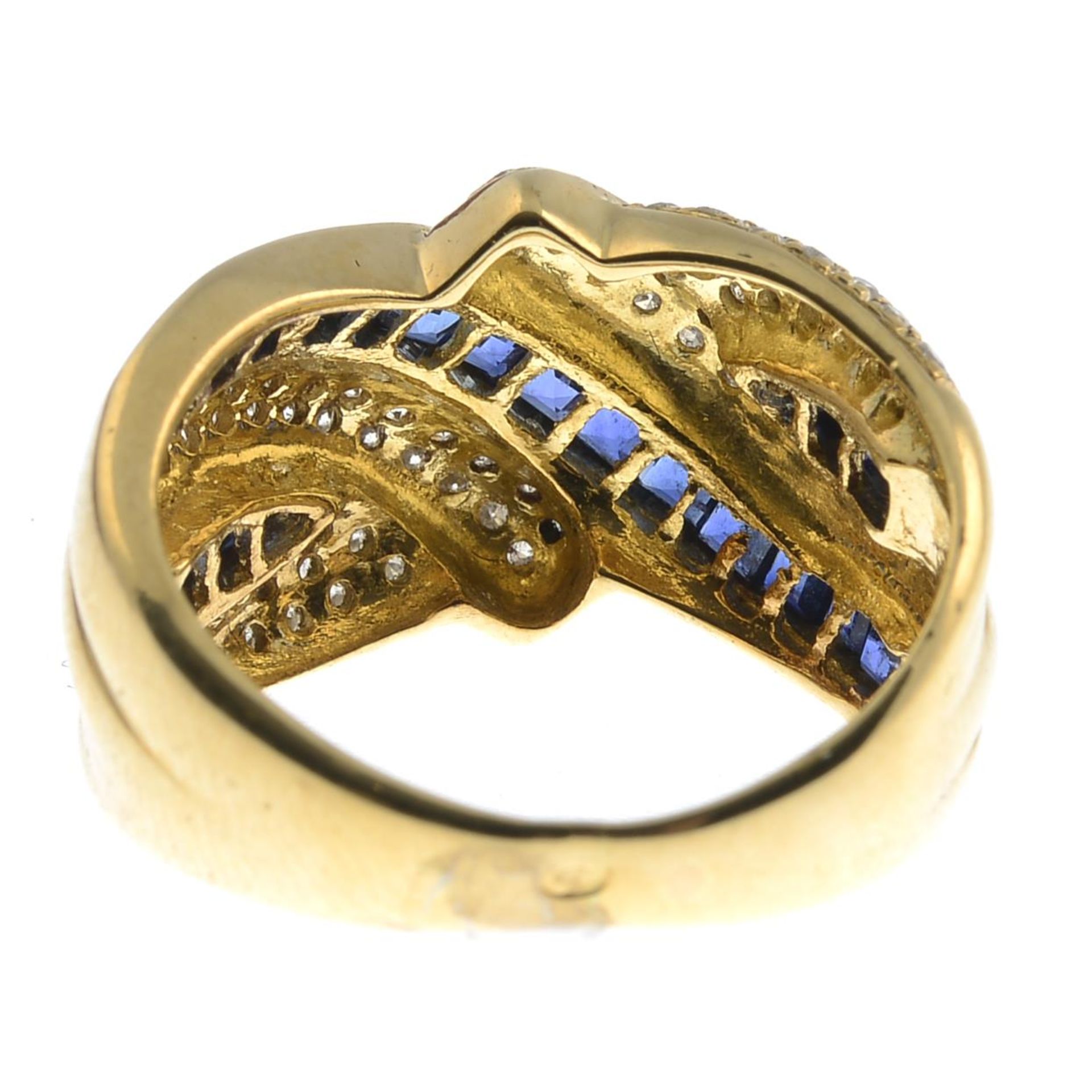 A brilliant-cut diamond and sapphire crossover ring.Estimated total diamond weight 0.45ct.Ring size - Image 2 of 3