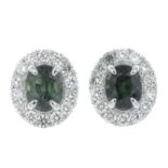 A pair of green sapphire and brilliant-cut diamond cluster earrings.Estimated total diamond weight