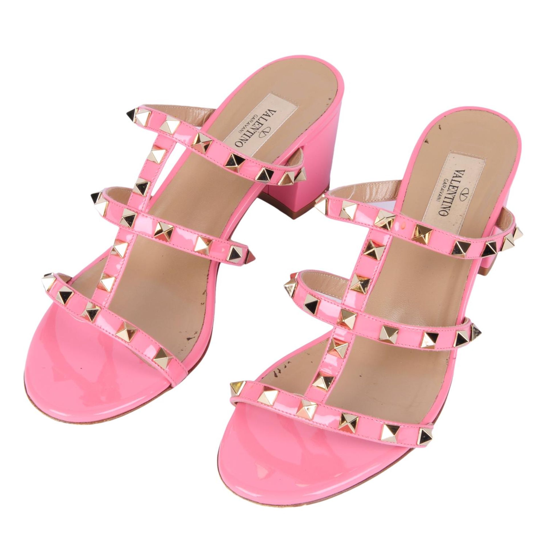 VALENTINO - a pair of pink patent leather Rockstud slip-on sandals.