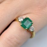 An 18ct gold emerald and brilliant-cut diamond three-stone ring.Emerald calculated weight 1.72cts,