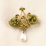 An early 20th century Art Nouveau gold peridot and pearl brooch.May be worn as a pendant.Peridot